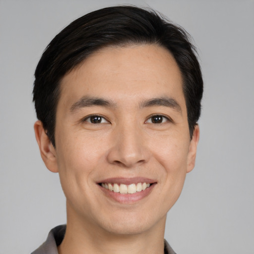 Joyful white young-adult male with short  black hair and brown eyes