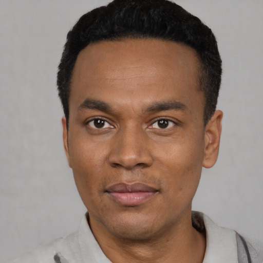 Joyful latino young-adult male with short  black hair and brown eyes