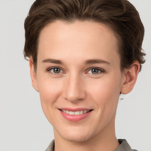 Joyful white young-adult female with short  brown hair and grey eyes