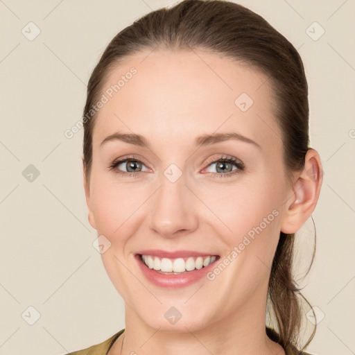 Joyful white young-adult female with long  brown hair and grey eyes