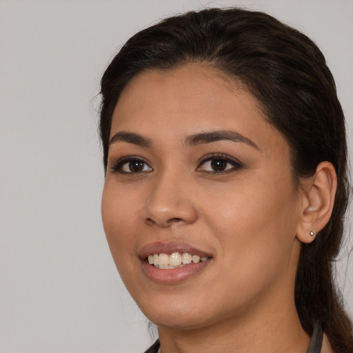 Joyful latino young-adult female with medium  brown hair and brown eyes