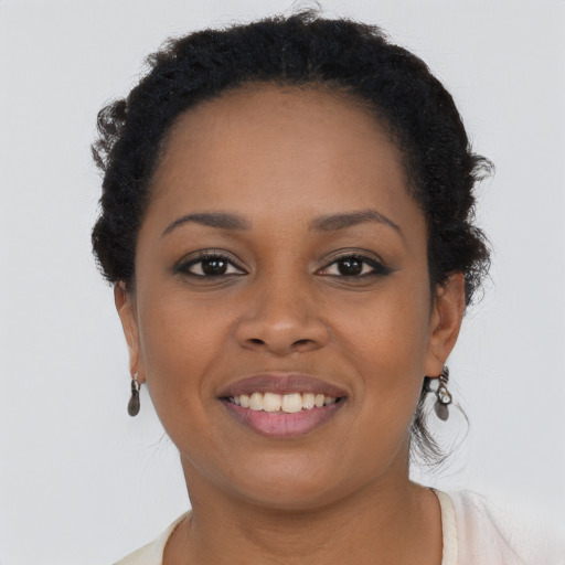 Joyful black young-adult female with short  brown hair and brown eyes