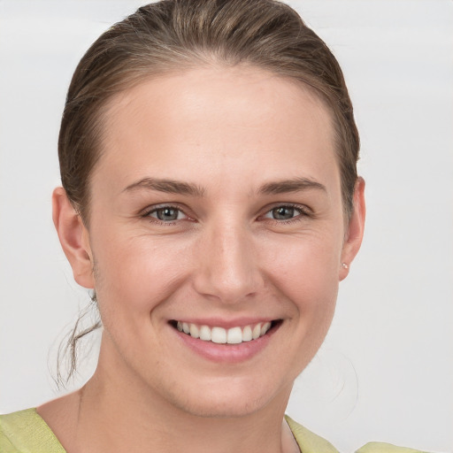 Joyful white young-adult female with medium  brown hair and grey eyes