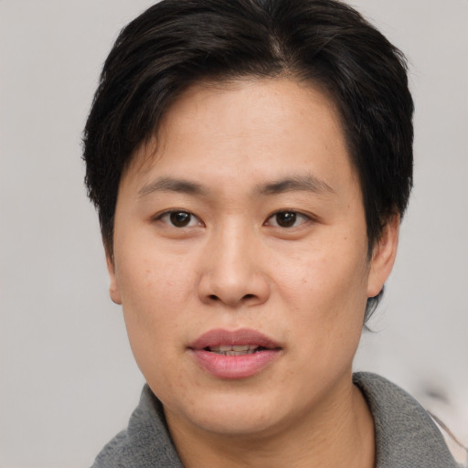 Joyful asian young-adult male with short  black hair and brown eyes