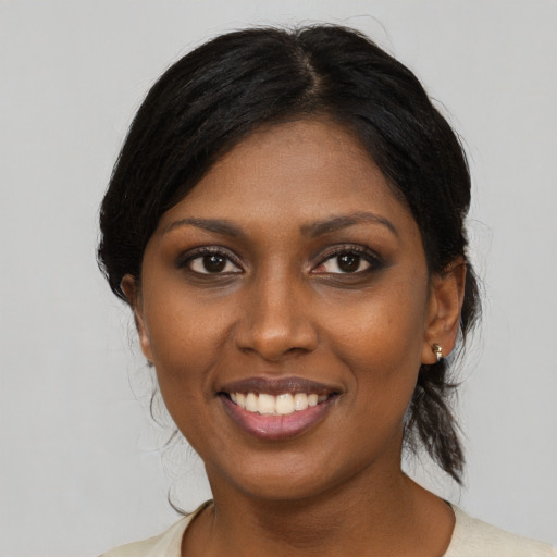 Joyful black young-adult female with medium  black hair and brown eyes