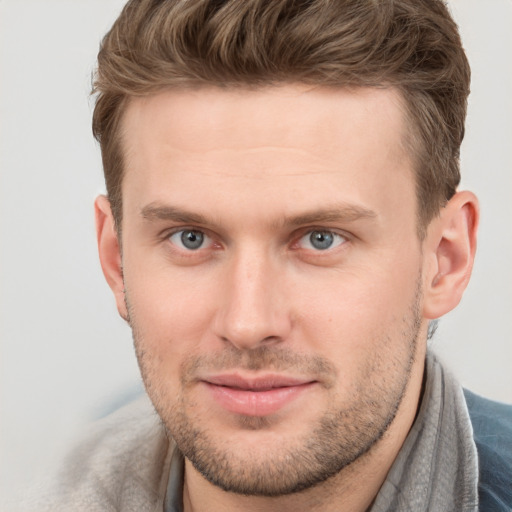 Joyful white young-adult male with short  brown hair and grey eyes