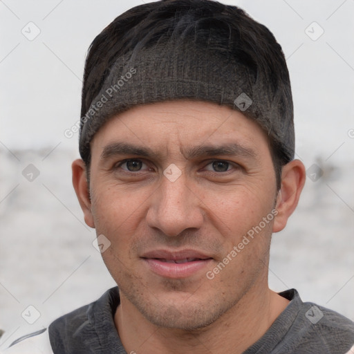 Joyful white adult male with short  black hair and brown eyes