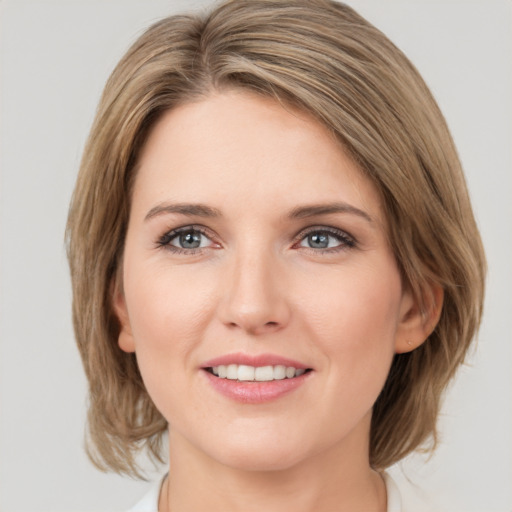 Joyful white young-adult female with medium  brown hair and green eyes