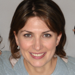 Joyful white adult female with medium  brown hair and blue eyes