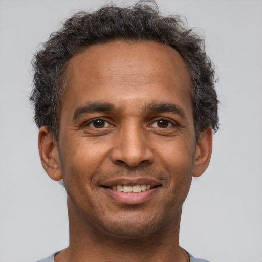 Joyful latino adult male with short  brown hair and brown eyes