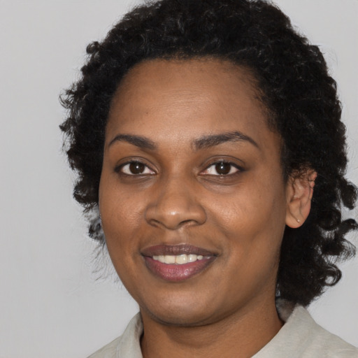 Joyful black young-adult female with medium  black hair and brown eyes