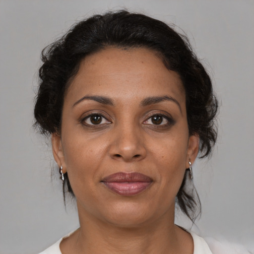 Joyful black adult female with medium  brown hair and brown eyes