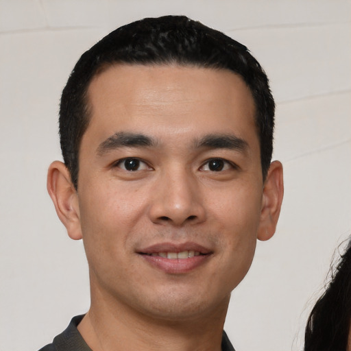 Joyful white young-adult male with short  black hair and brown eyes