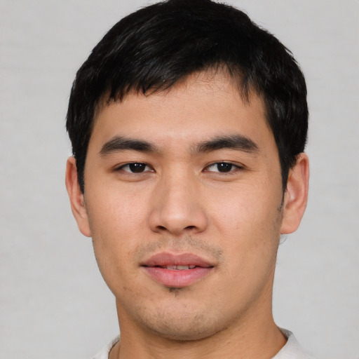 Joyful asian young-adult male with short  black hair and brown eyes