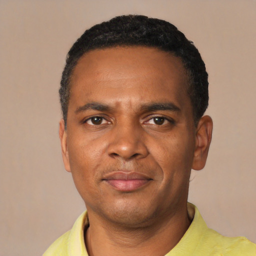 Joyful black young-adult male with short  black hair and brown eyes