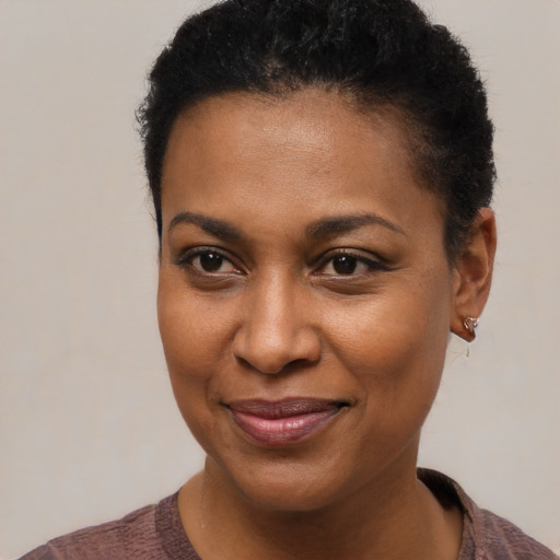 Joyful black young-adult female with short  brown hair and brown eyes