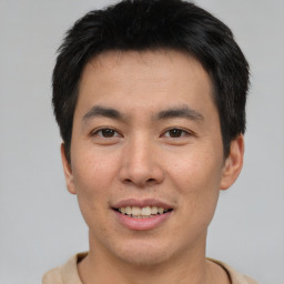 Joyful asian young-adult male with short  brown hair and brown eyes