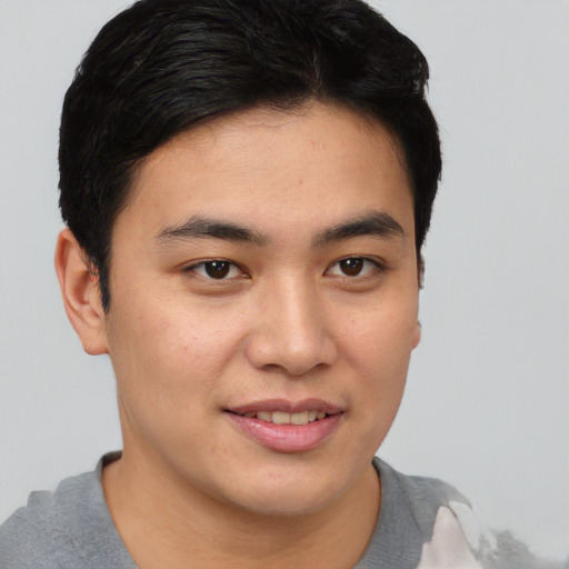 Joyful asian young-adult male with short  brown hair and brown eyes