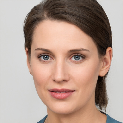 Joyful white young-adult female with medium  brown hair and grey eyes