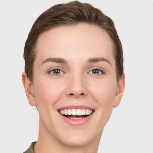 Joyful white young-adult female with short  brown hair and grey eyes