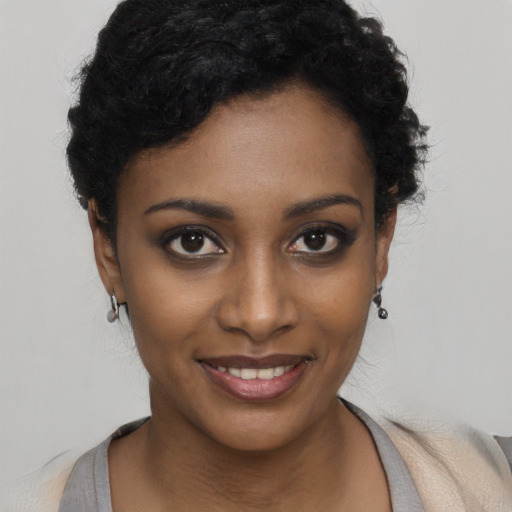 Joyful black young-adult female with short  black hair and brown eyes