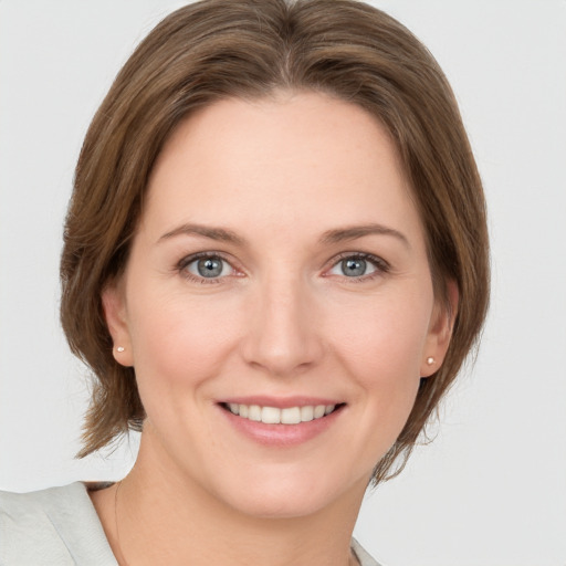 Joyful white young-adult female with medium  brown hair and grey eyes