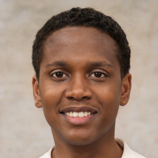 Joyful black young-adult male with short  brown hair and brown eyes