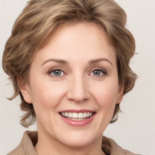 Joyful white young-adult female with medium  brown hair and green eyes