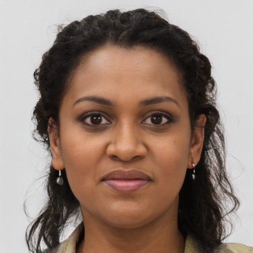 Joyful black young-adult female with long  brown hair and brown eyes