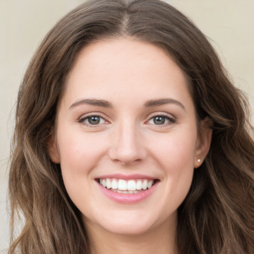 Joyful white young-adult female with long  brown hair and green eyes