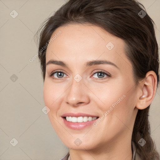 Joyful white young-adult female with long  brown hair and brown eyes