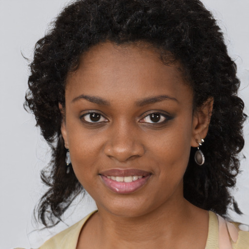 Joyful black young-adult female with long  brown hair and brown eyes