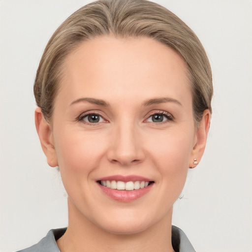 Joyful white young-adult female with short  brown hair and blue eyes