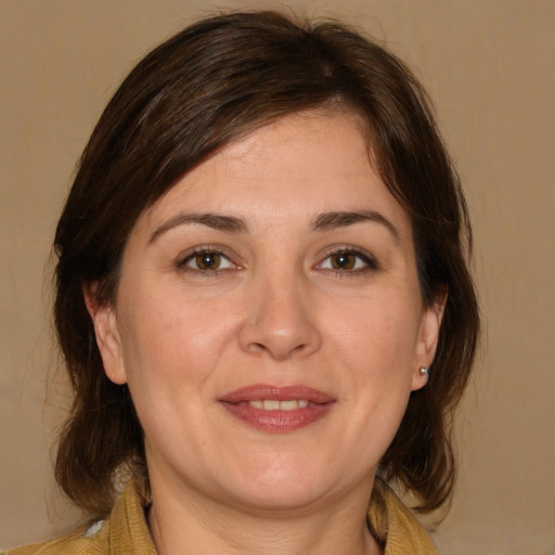 Joyful white adult female with medium  brown hair and brown eyes