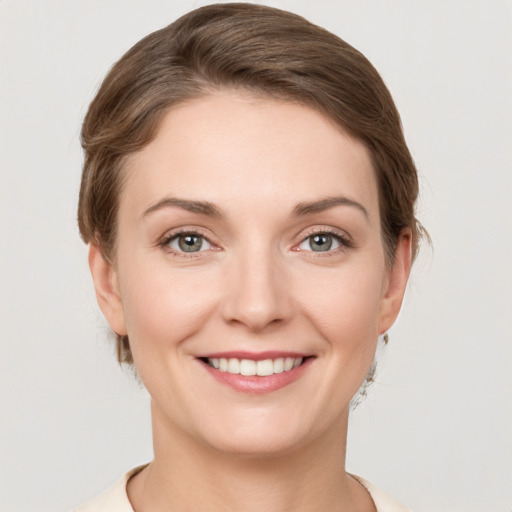 Joyful white young-adult female with short  brown hair and grey eyes