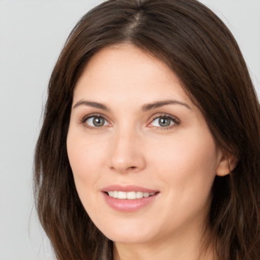 Joyful white young-adult female with long  brown hair and brown eyes