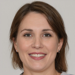 Joyful white adult female with medium  brown hair and brown eyes