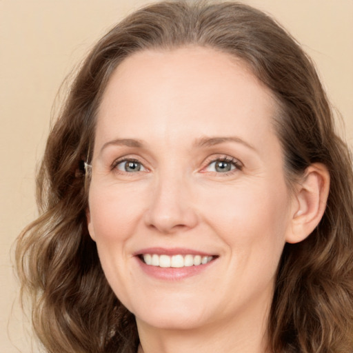 Joyful white young-adult female with long  brown hair and green eyes