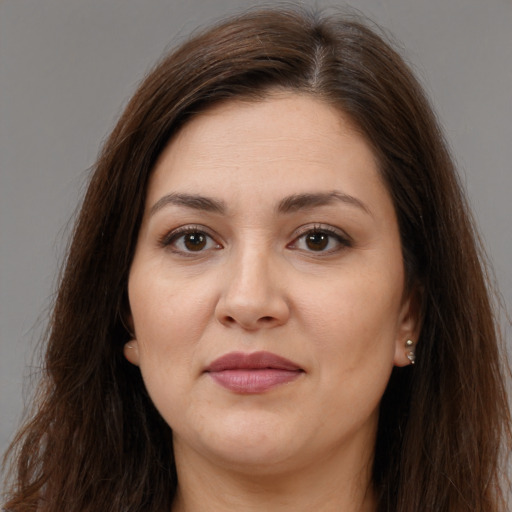 Joyful white adult female with long  brown hair and brown eyes