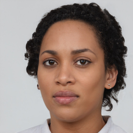 Joyful black young-adult female with medium  black hair and brown eyes