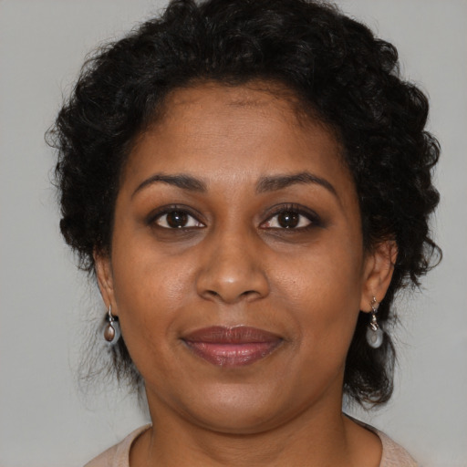 Joyful black adult female with medium  brown hair and brown eyes