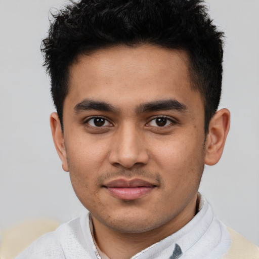 Joyful latino young-adult male with short  brown hair and brown eyes