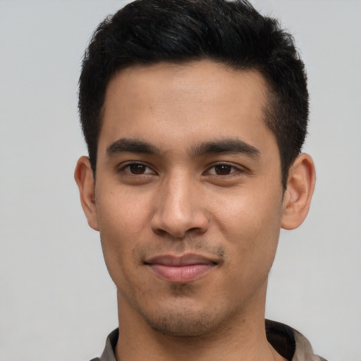 Joyful latino young-adult male with short  black hair and brown eyes