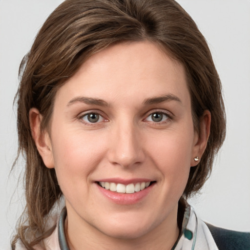 Joyful white young-adult female with medium  brown hair and grey eyes