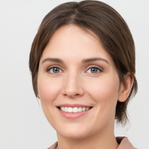 Joyful white young-adult female with medium  brown hair and grey eyes