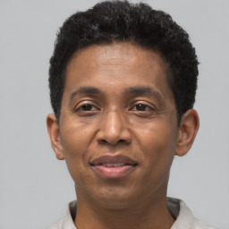 Joyful black adult male with short  brown hair and brown eyes