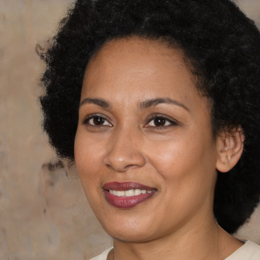 Joyful black adult female with medium  brown hair and brown eyes