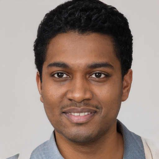 Joyful black young-adult male with short  black hair and brown eyes