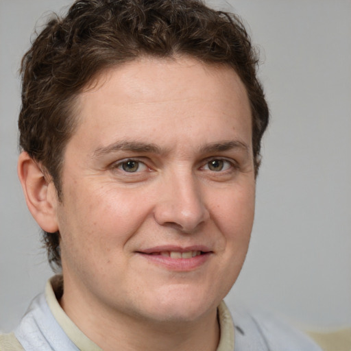 Joyful white adult male with short  brown hair and grey eyes