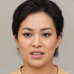 Joyful asian young-adult female with medium  black hair and brown eyes